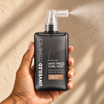 Unveiled Cosmetics Anti-Frizz Curl Mist bottle in hand